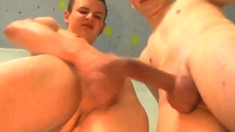 2 young boys having a cockfight in the shower